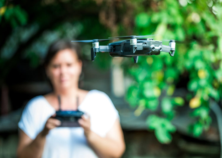 Woman operating a quadcopter in accordance with FAA drone regulations
