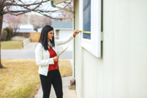 Young Adult Millennial Female Appraiser Measuring Home Features and Assessing Value in Western Colorado