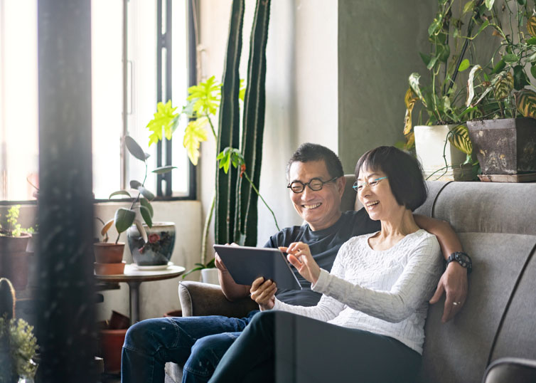 Middle-aged couple exploring retirement resources on an iPad or tablet