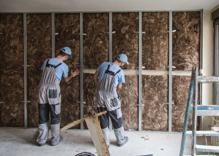 Construction site close up with workers installing glass wool sustainable insulation